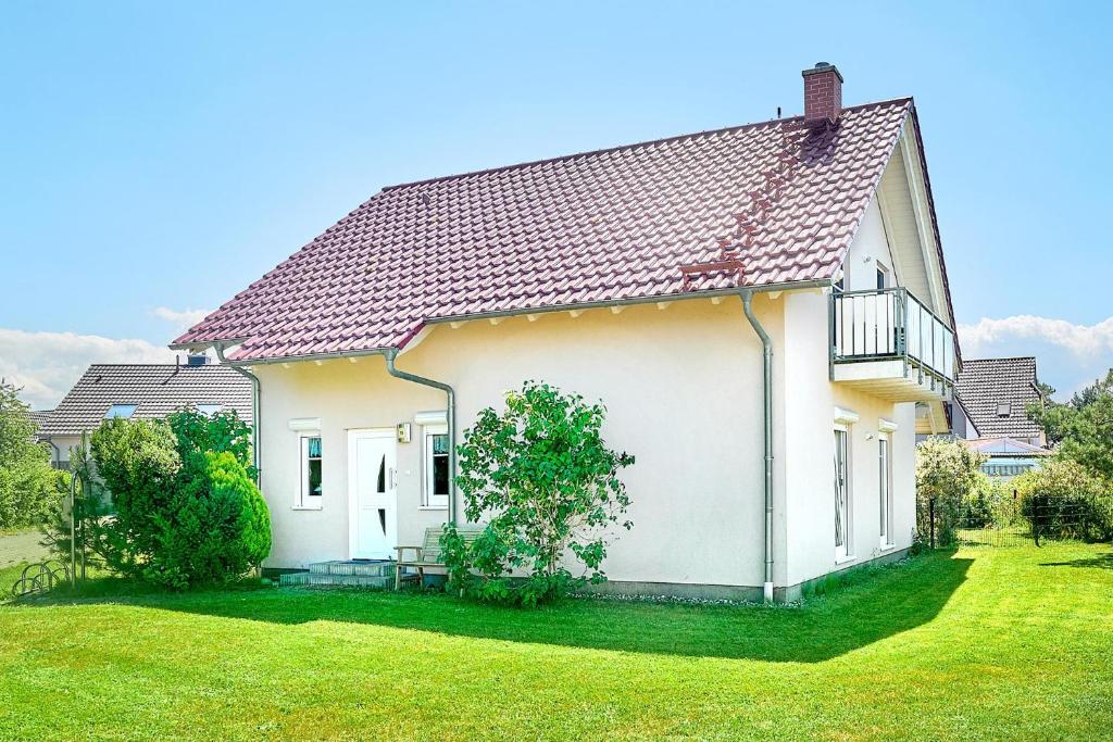 a white house with a red roof at Am Redensee in Fuhlendorf