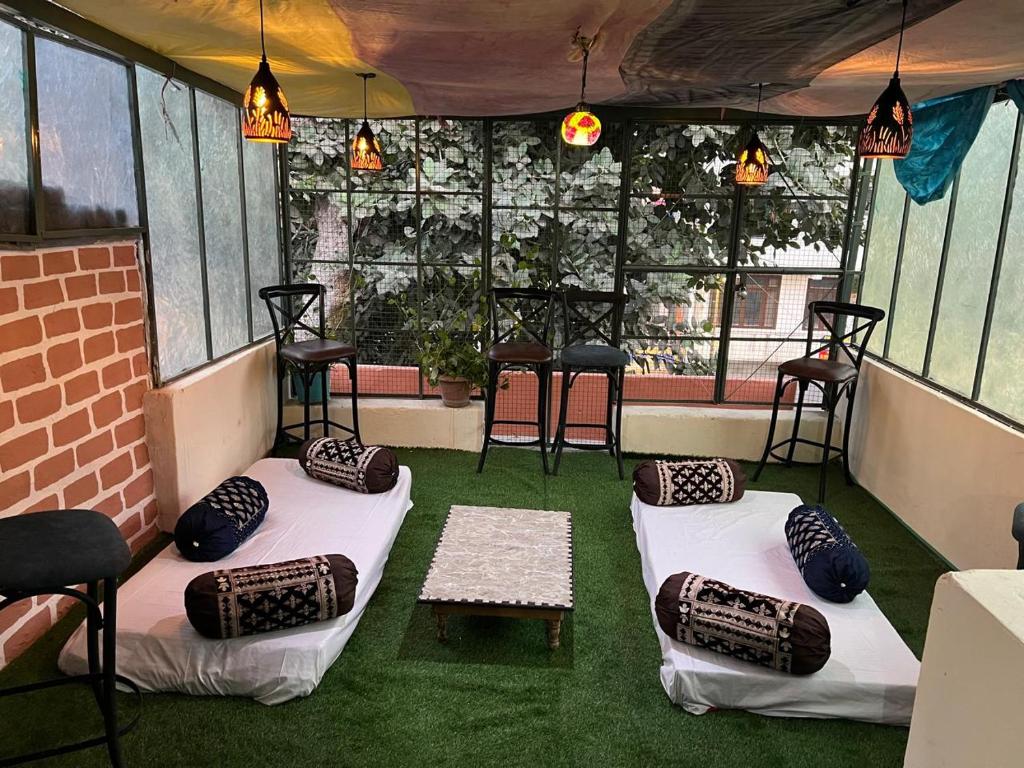 a room with some chairs and a table and some windows at Rudra The Stay in Jaipur