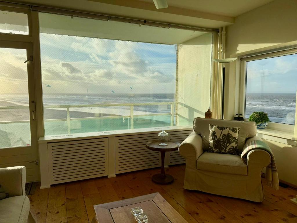 una sala de estar con una gran ventana con vistas al océano en Blue Bay Zandvoort, en Zandvoort