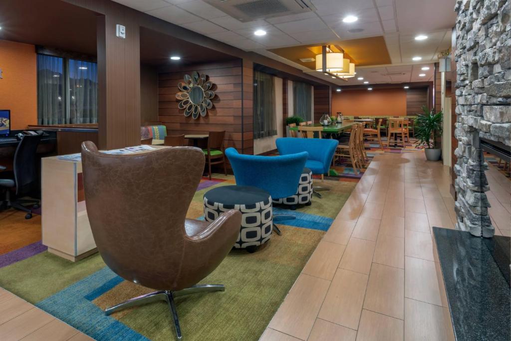 a lobby with a chair and tables and chairs at Fairfield Inn Salt Lake City South in Murray