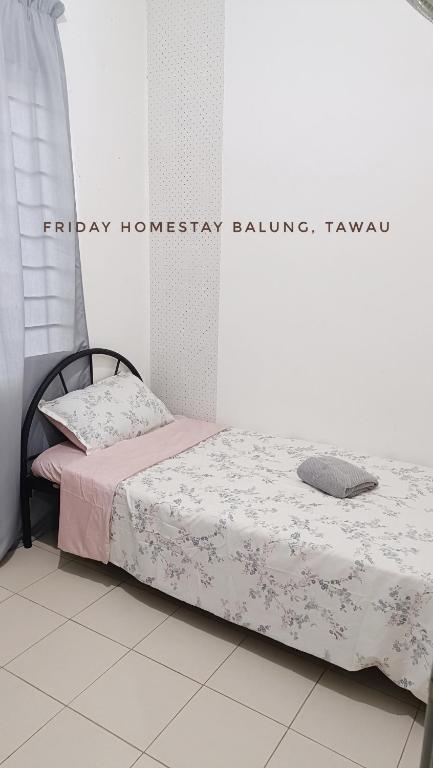 a bedroom with a bed in a room with a sign at Friday Homestay Taman Sawit Balung, Tawau in Tawau