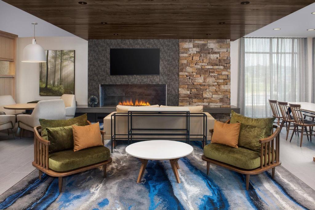 un soggiorno con due sedie e un camino di Fairfield Inn & Suites by Marriott Knoxville Lenoir City/I-75 a Lenoir City