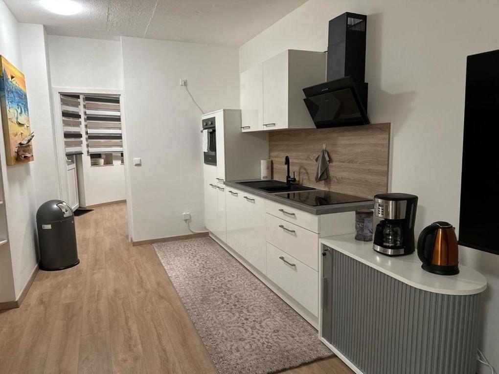 a white kitchen with a sink and a microwave at POLAT Apartments 8 in Essen