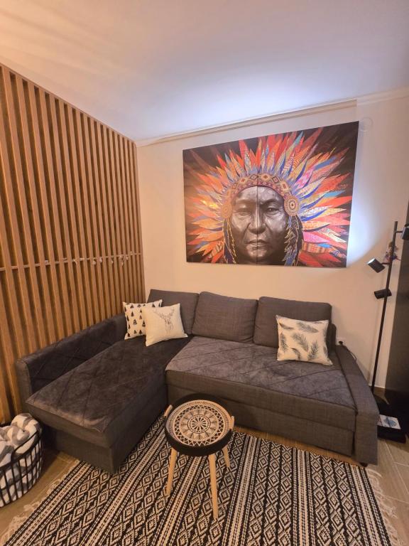a living room with a couch and a painting on the wall at Kai Apartman in Kopaonik