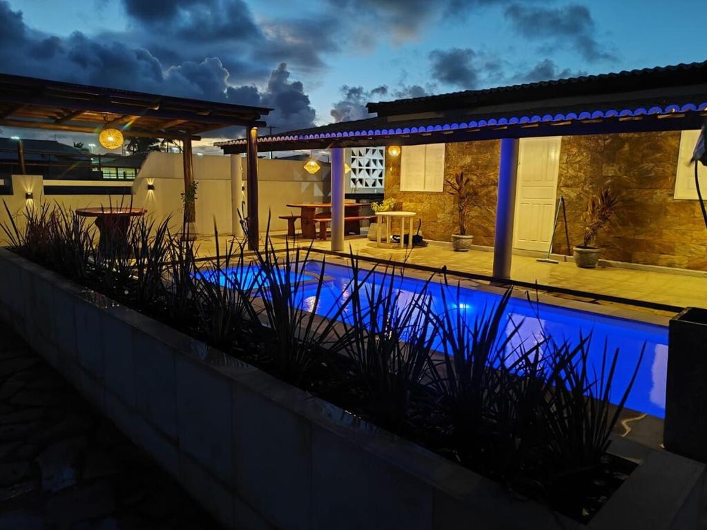 a swimming pool in front of a house at night at Casa PE NA AREIA na Praia da Caueira com Piscina e SPA in Praia Da Caueira