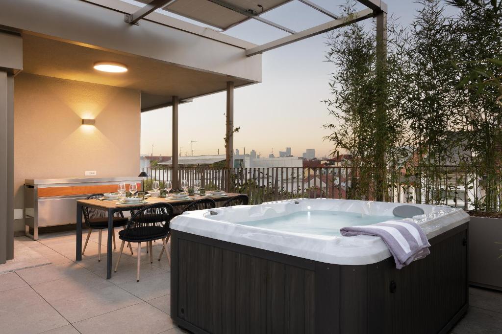 a large bath tub sitting on a patio with a table at Compagnoni12 Luxury penthouse with private Jacuzzi and SPA in Milan