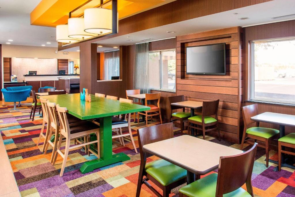 a restaurant with tables and chairs and a flat screen tv at Fairfield Inn & Suites Peru in Peru