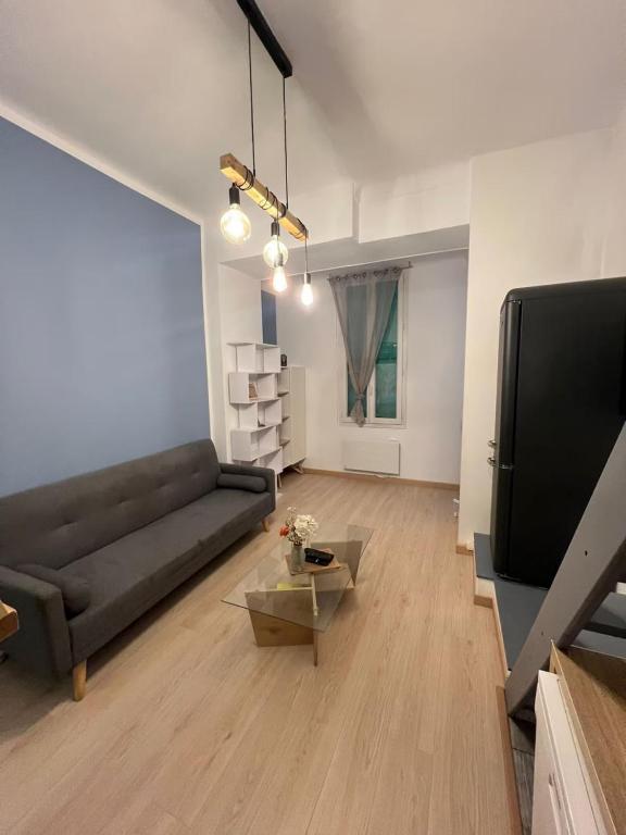 un salon avec un canapé et une télévision dans l'établissement Appartement en centre-ville, proche gares, à Nice