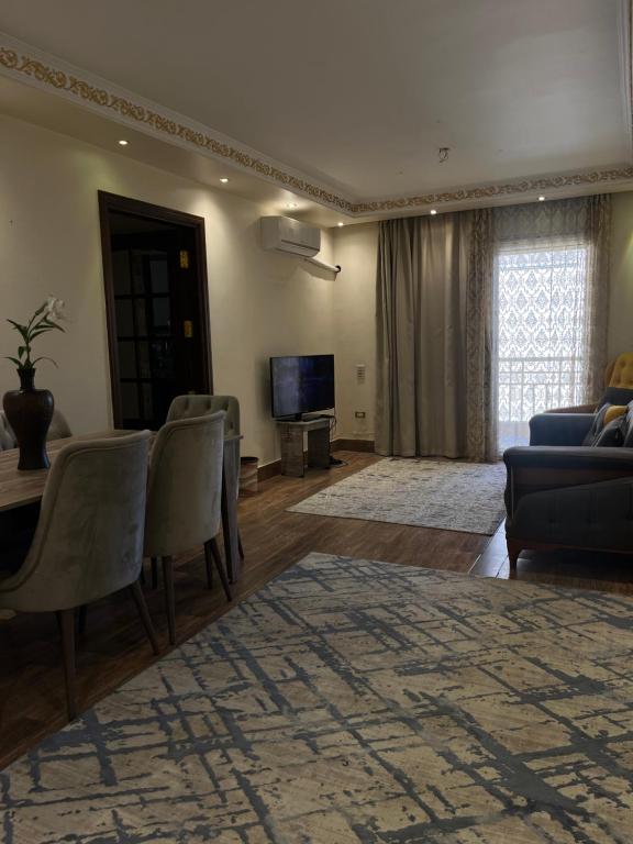 uma sala de estar com um sofá e uma TV em Furnished apartment - Madinaty em Madinaty