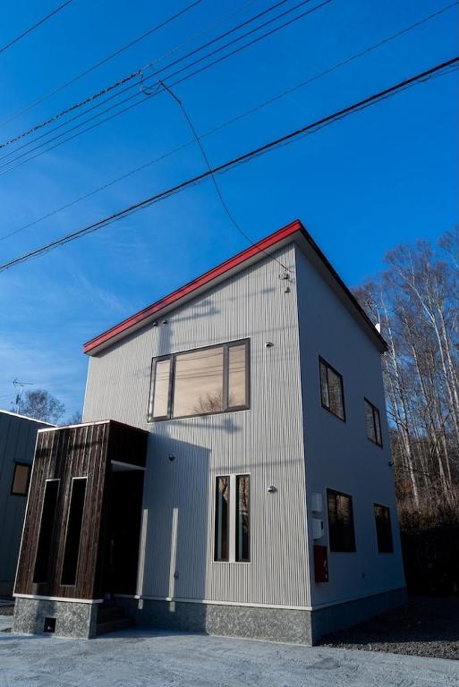 a white building with a red roof at Niseko Yu Villa D in Niseko