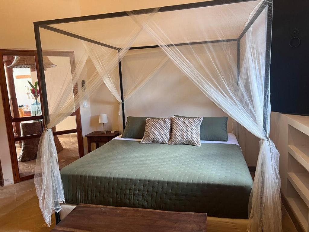 a bedroom with a canopy bed with two pillows at Central Park Luxurious Historical Home With Pool in Granada