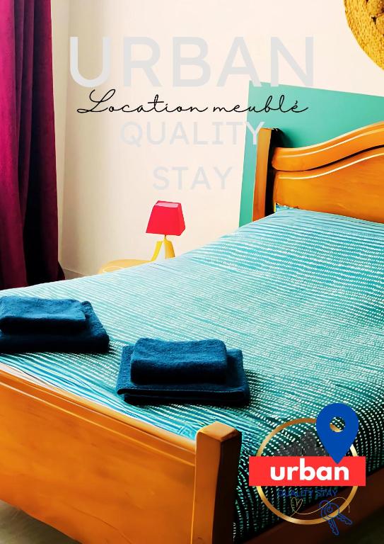 un lit avec deux serviettes bleues dessus dans l'établissement Grande chambre privée au DUPLEX DU CLOITRE MOISSAC, à Moissac