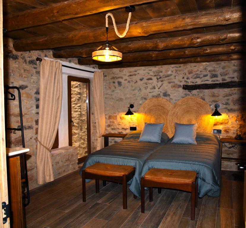 ein Schlafzimmer mit einem großen Bett mit blauen Kissen in der Unterkunft Masía El Refugio in Villafranca del Cid
