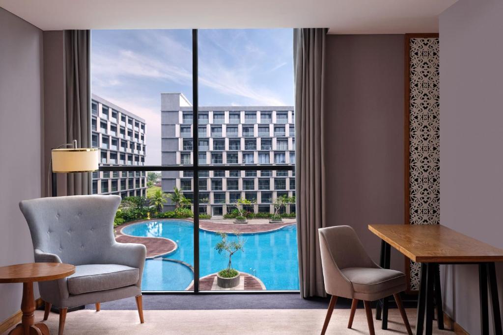 a room with a view of a pool from a hotel room at Four Points by Sheraton Balikpapan in Balikpapan