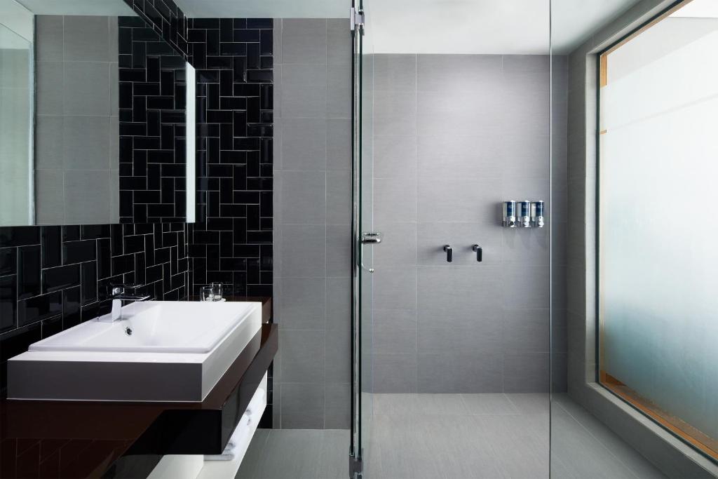 a bathroom with a sink and a glass shower at Four Points by Sheraton Balikpapan in Balikpapan