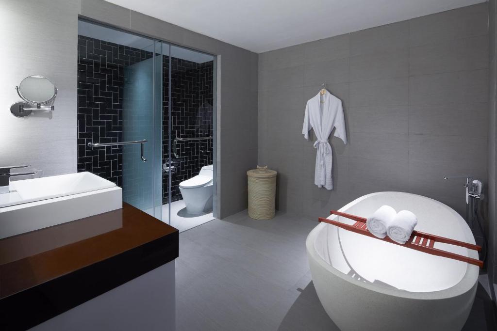 a bathroom with a tub and a sink and a toilet at Four Points by Sheraton Balikpapan in Balikpapan