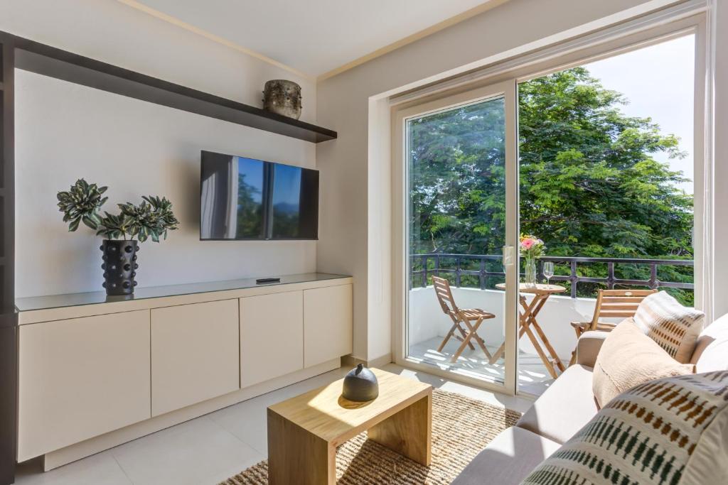 a living room with a couch and a tv at El Tigre Golf Retreat, Condominios Taheima in Nuevo Vallarta 
