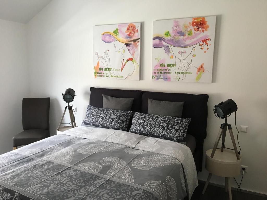 a bedroom with a bed with three pictures on the wall at Gutunterdachgebracht in Langerwehe