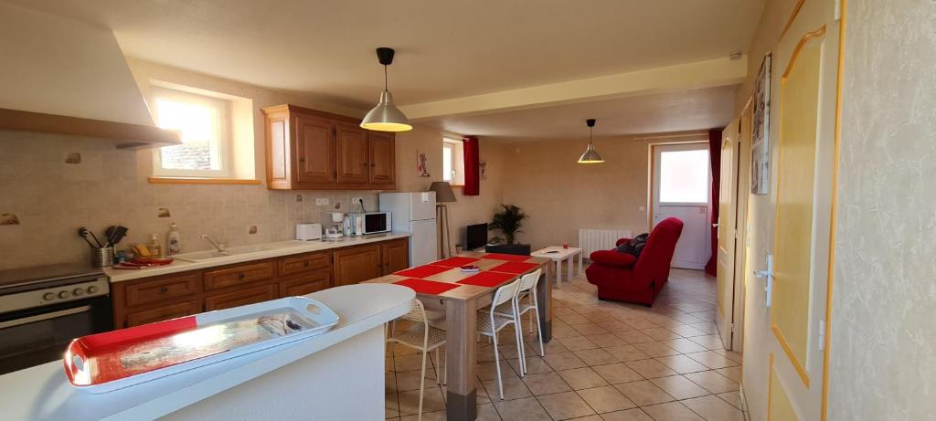 eine Küche mit einem Tisch und einem roten Stuhl darin in der Unterkunft Gite le petit village 7 kms du Zoo de Beauval in Saint-Romain-sur-Cher
