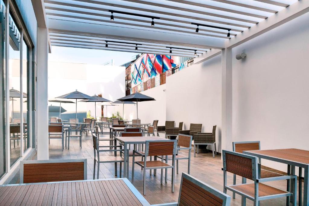 a dining room with tables and chairs and windows at Fairfield Inn & Suites by Marriott Tijuana in Tijuana