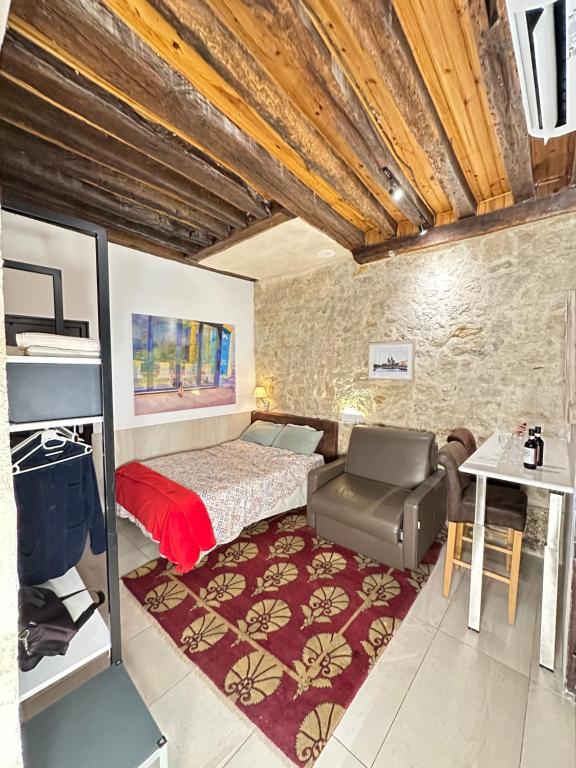 une chambre avec un lit, une chaise et une table dans l'établissement Charles V Flat Ground Floor, à Paris