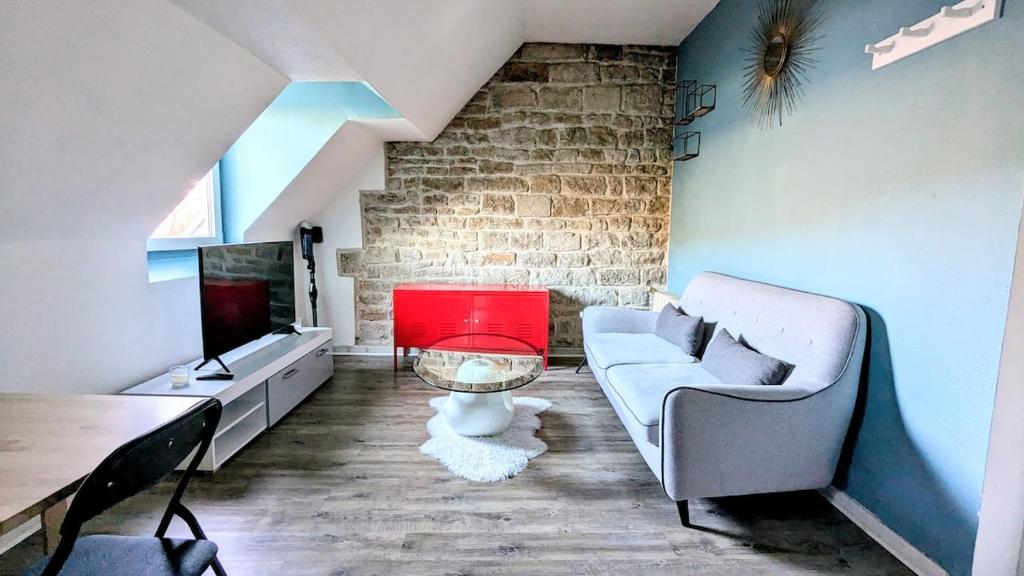 a living room with a couch and a tv at La Petite Parenthèse in Beure