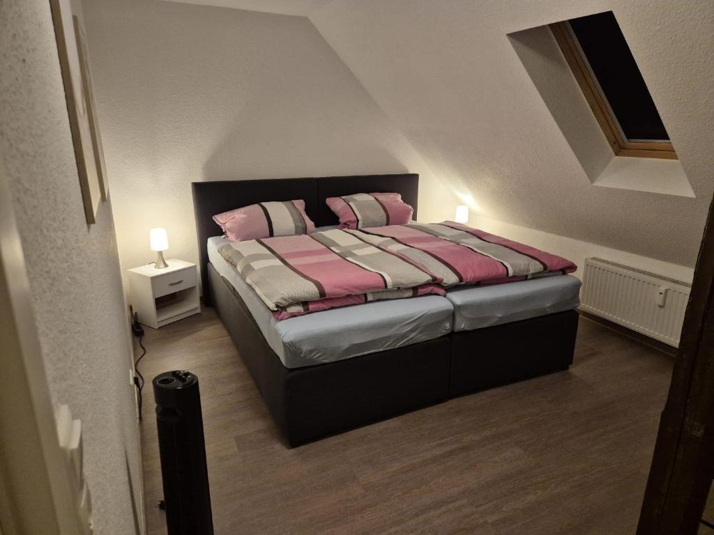 a bedroom with a bed with pink and white pillows at Apartment-am-Burgberg, Harztor in Harztor