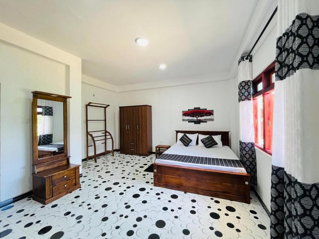 a bedroom with a bed and a dresser and a mirror at The Off Road Homestay in Kandy