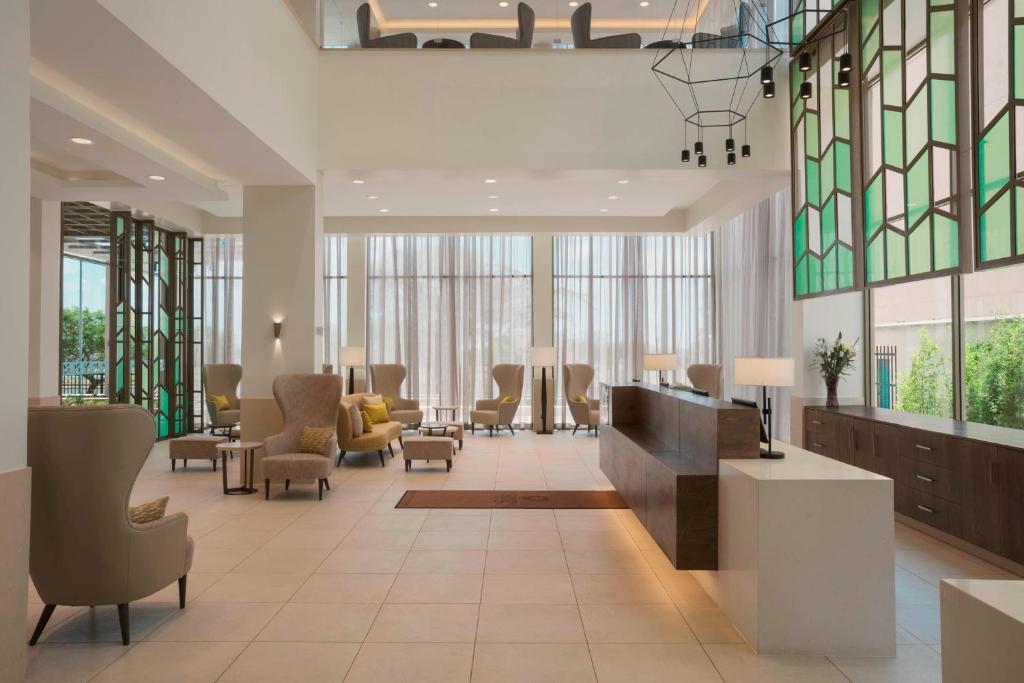 a lobby with a waiting area with chairs and tables at Four Points by Sheraton Nairobi Airport in Nairobi