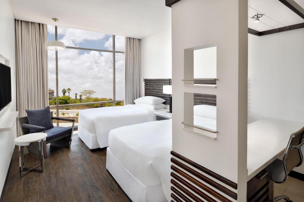 a hotel room with two beds and a window at Four Points by Sheraton Nairobi Airport in Nairobi