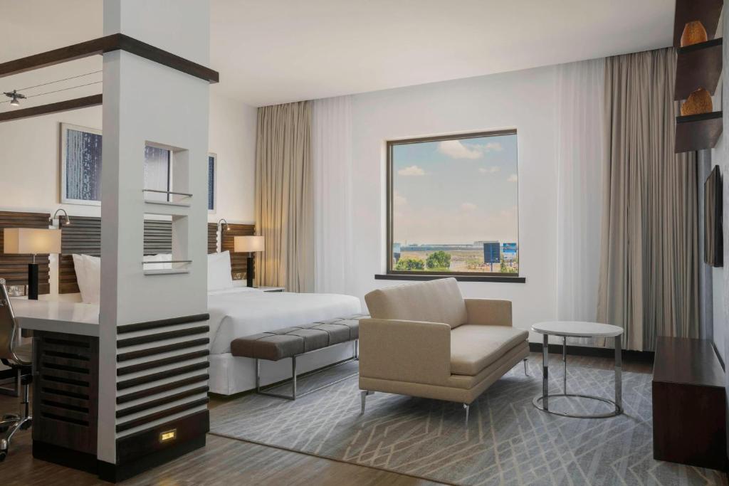 a hotel room with a bed and a chair at Four Points by Sheraton Nairobi Airport in Nairobi