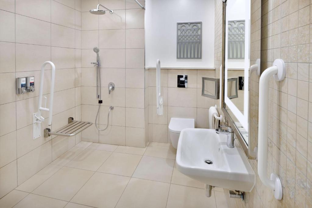 a white bathroom with a sink and a shower at Four Points by Sheraton Nairobi Airport in Nairobi
