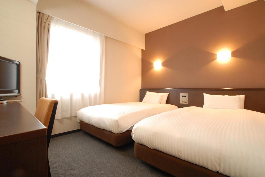 Postel nebo postele na pokoji v ubytování AB Hotel Okazaki