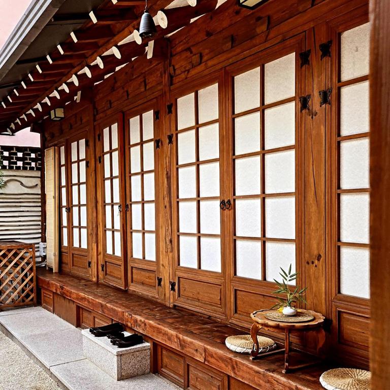 a wooden porch with windows and a table at JoongRimJae - Hanok in Seoul