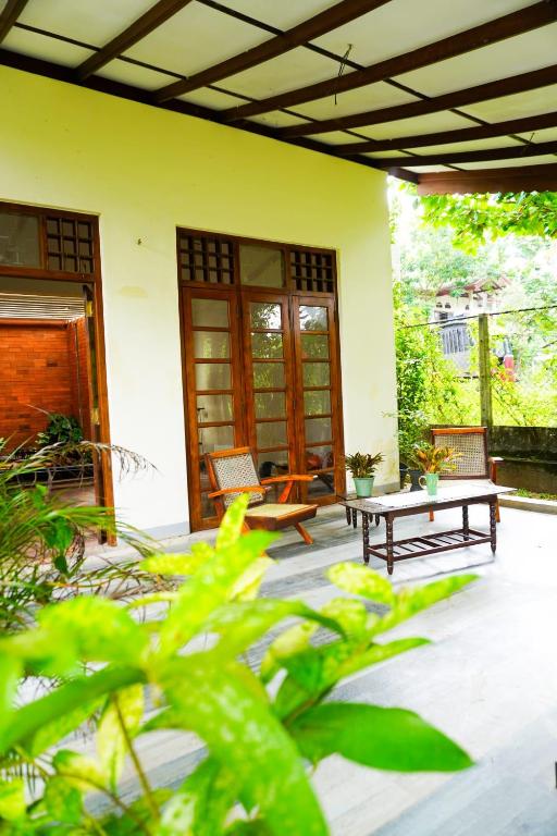 a patio with two benches and a table on a house at Olive Green Villa in Negombo for Airport Transit in Katunayaka