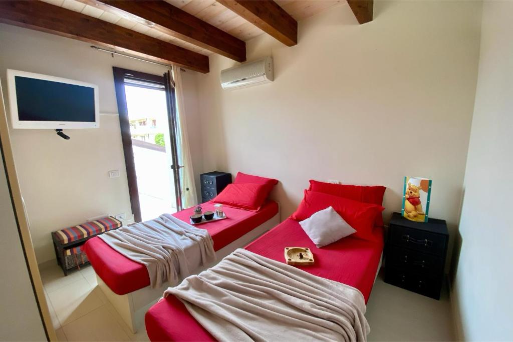 Pokój z dwoma łóżkami, kanapą i telewizorem w obiekcie Boutique House w mieście Torre Grande