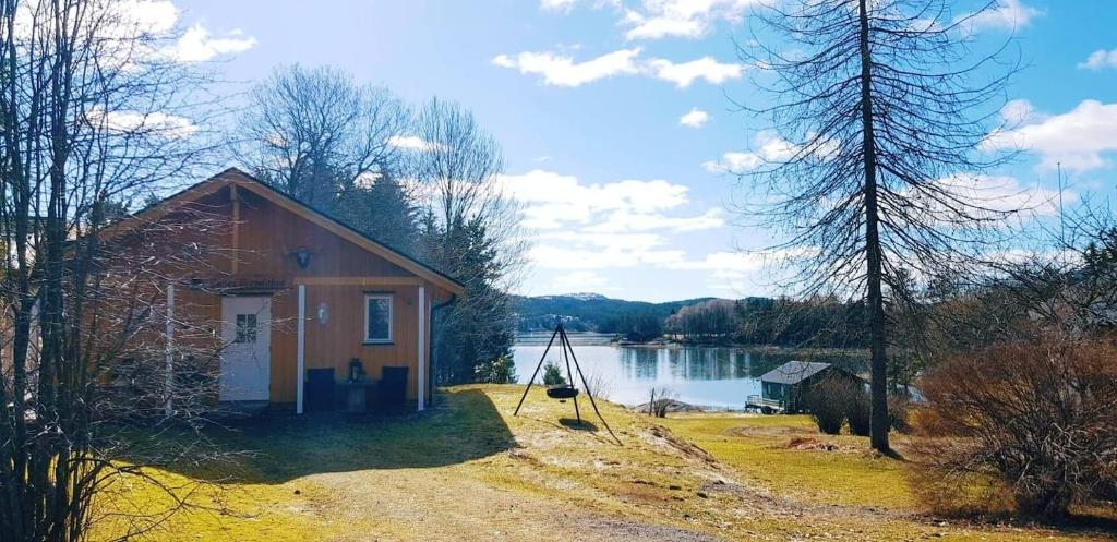 una piccola casa sulla riva di un lago di Gjestehus på bondegård, med båtutleie a Namsos