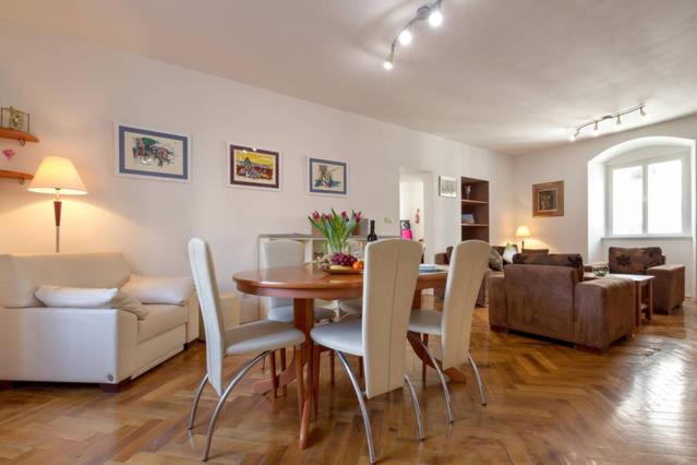 a dining room and living room with a table and chairs at Apartment See Everlasting Split in Split