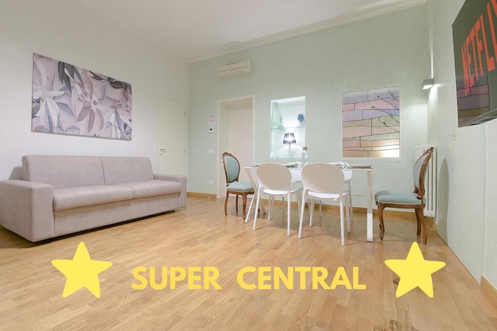 a living room with a table and chairs and a couch at SUPER CENTRAL - Antique flat in Bologna