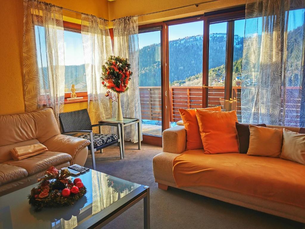 a living room with a couch and a large window at Snowflake Chalet ,Donovaly in Donovaly
