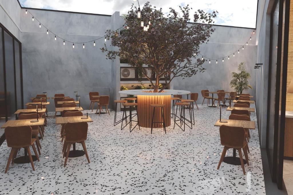 a group of tables and chairs in a room at Four Points by Sheraton Matosinhos in Matosinhos