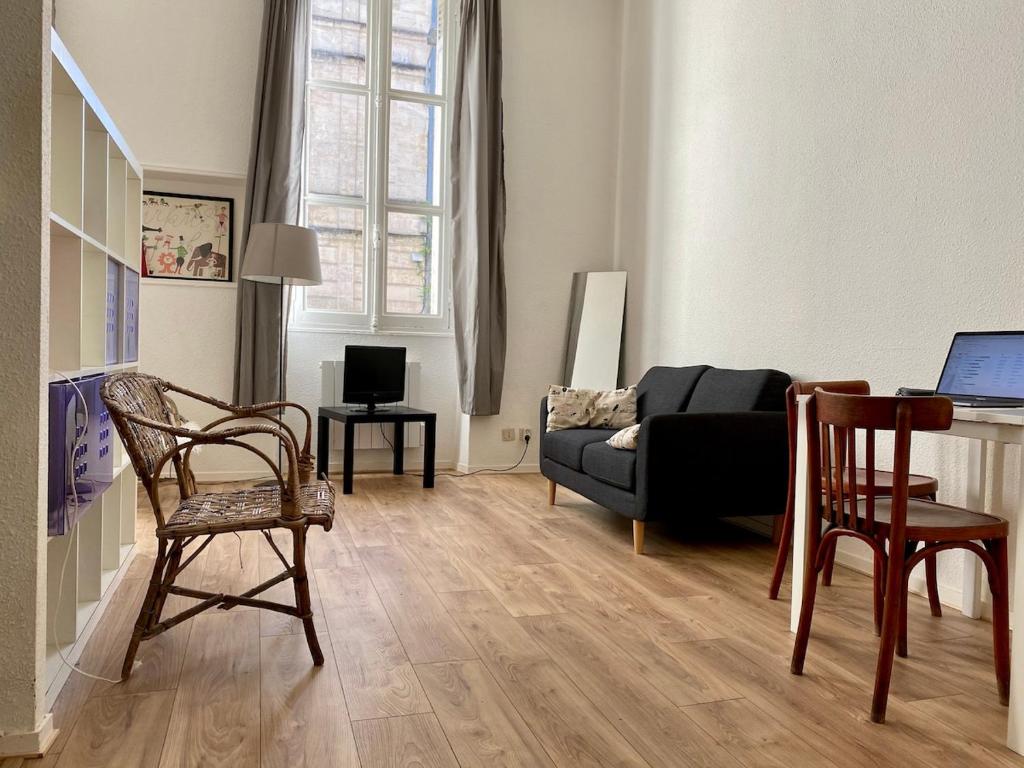 un salon avec un canapé, une table et des chaises dans l'établissement Superbe pied à terre en centre ville, à Bordeaux