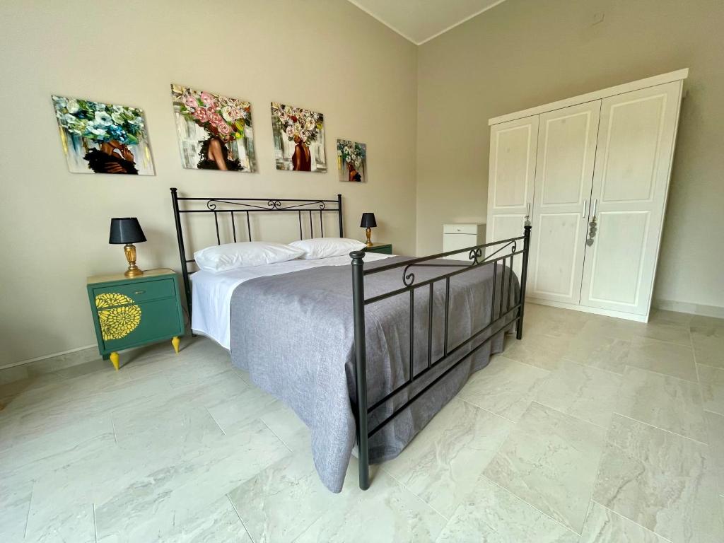 ein Schlafzimmer mit einem Bett und einige Bilder an der Wand in der Unterkunft Casa Gaia - Proppro SRL - Vicino Milazzo in San Biagio