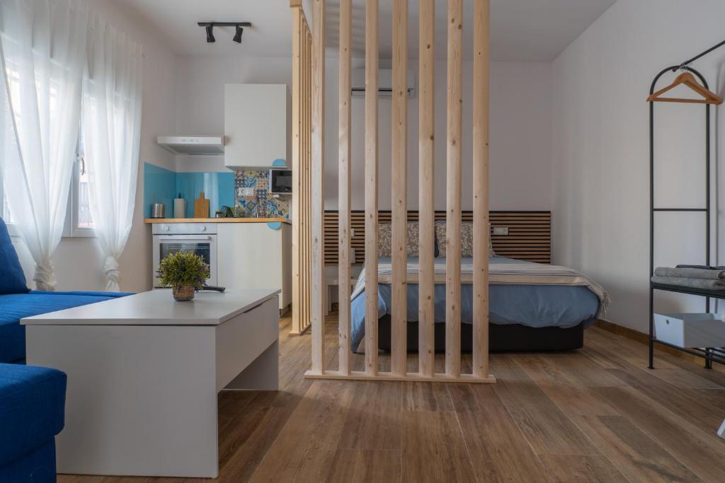 a bedroom with a bed and a room with a table at Estudio completo a estrenar en Triana in Seville