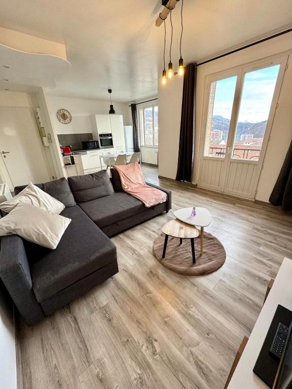 un salon avec un canapé et une table dans l'établissement Panorama, à Bellegarde-sur-Valserine