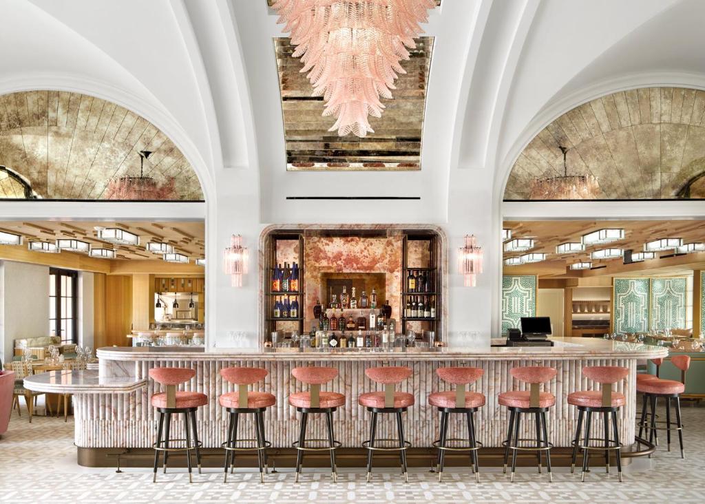 un bar con taburetes rojos en una habitación grande en Palm House Hotel Palm Beach, en Palm Beach