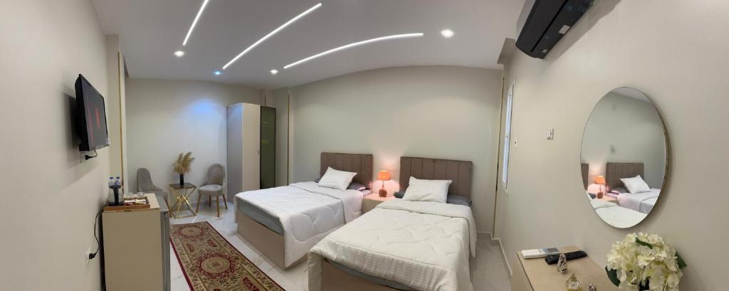 Pokój hotelowy z 2 łóżkami i lustrem w obiekcie Hapi Pyramids Hotel w Kairze