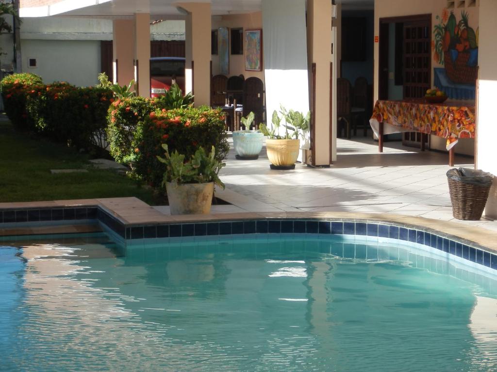 a swimming pool in front of a house at Pousada Venezia in Fortaleza