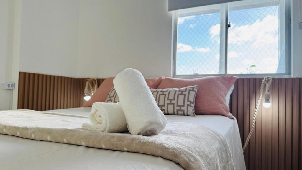 ein Bett mit einem Stapel Handtücher darüber in der Unterkunft PROMOÇÃO DE INAUGURAÇÃO- 13 andar - vista mar in São José da Coroa Grande