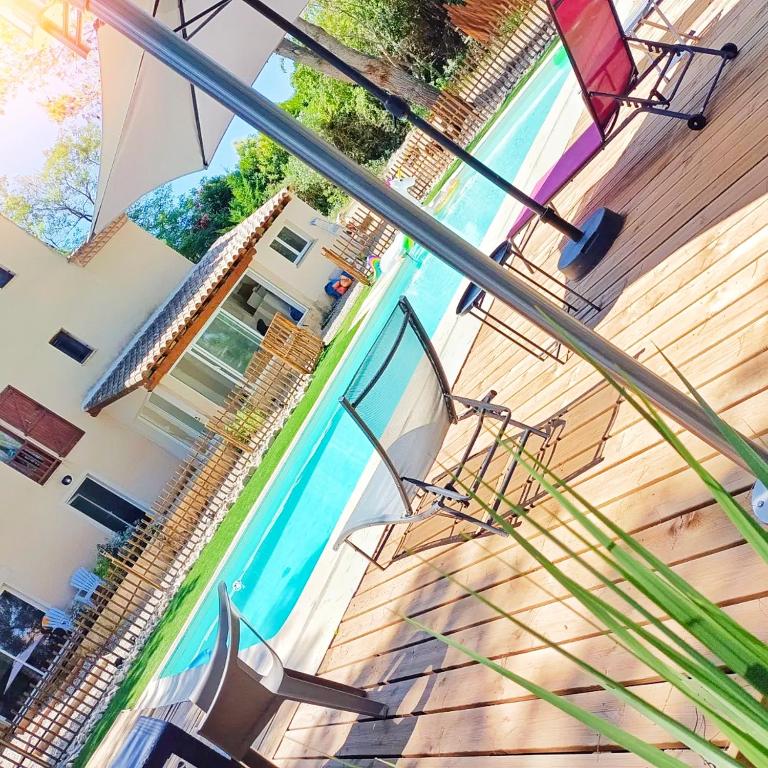 - une vue sur la piscine avec un parasol dans l'établissement Appartement jacuzzi privé à 3 minutes cité médiévale, à Carcassonne